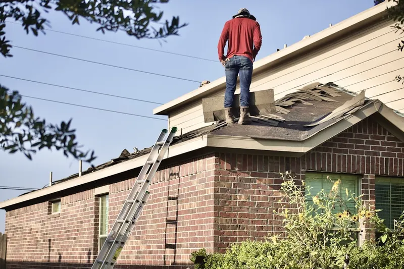 Professional roofer working on a residential roof in Merrick